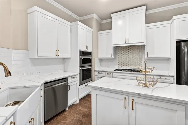 a living room with stainless steel appliances granite countertop furniture and a chandelier