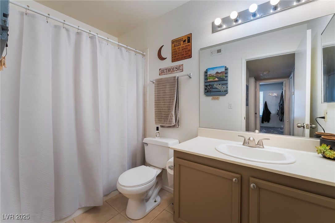 1575 West Warm Springs Road, Unit 2822 Henderson, NV 89014 - Photo 32 of 37 Bathroom with toilet, tile patterned floors, vanity, and a shower with shower curtain