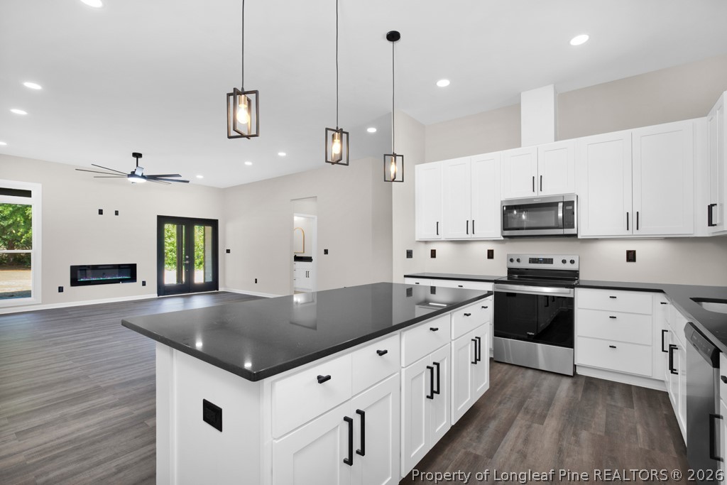 3025 Old Stage Road South Erwin, NC 28339 - Photo 17 of 50 a kitchen with stainless steel appliances granite countertop a sink a stove and a wooden floors
