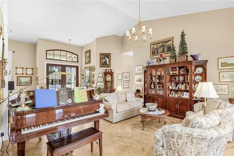 a living room with furniture a chandelier and a dining table