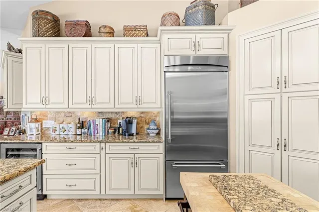 a kitchen with granite countertop a refrigerator and cabinets