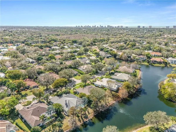 an aerial view of ocean and residential houses with outdoor space
