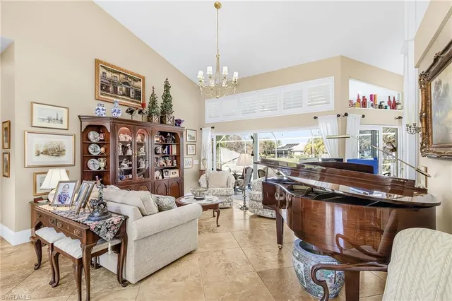 a living room with furniture a chandelier and a dining table