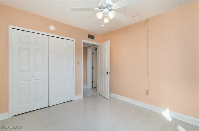 an empty room with a ceiling fan and a window