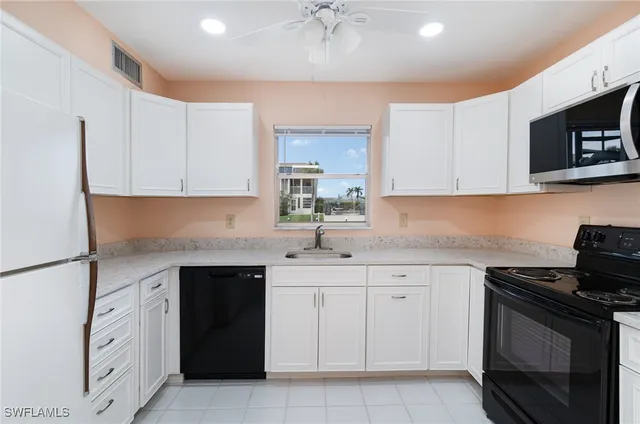 a kitchen with white cabinets and a stove top oven