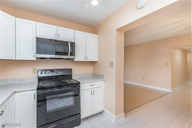 a kitchen with granite countertop white cabinets and stainless steel appliances