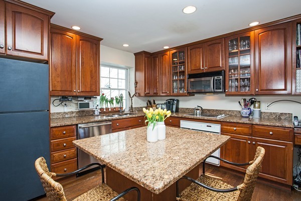 38 Dwhinda Road Newton, MA 02468 - Photo 16 of 30 a kitchen with kitchen island granite countertop wooden cabinets a stove top oven a sink and dishwasher