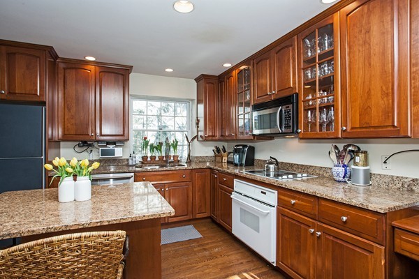 38 Dwhinda Road Newton, MA 02468 - Photo 17 of 30 a kitchen with stainless steel appliances granite countertop a sink dishwasher stove and microwave with wooden cabinets