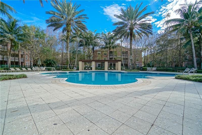6702 West Sample Road, Unit 6702 Coral Springs, FL 33067 - Photo 8 of 8 a view of a swimming pool with palm trees