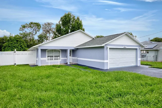 a front view of a house with a garden and yard