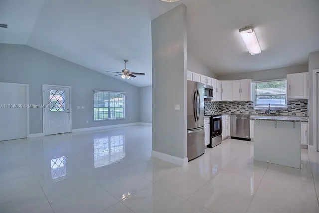 a kitchen with stainless steel appliances granite countertop a refrigerator and a stove top oven