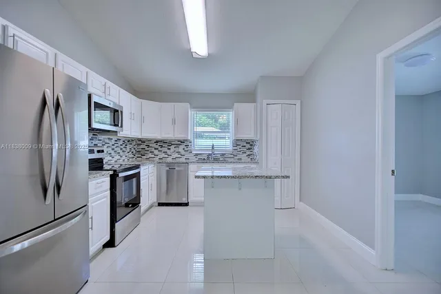 a kitchen with a refrigerator sink and cabinets