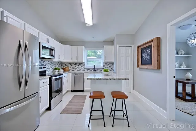 a kitchen with stainless steel appliances granite countertop a refrigerator a stove a sink dishwasher and white cabinets with wooden floor