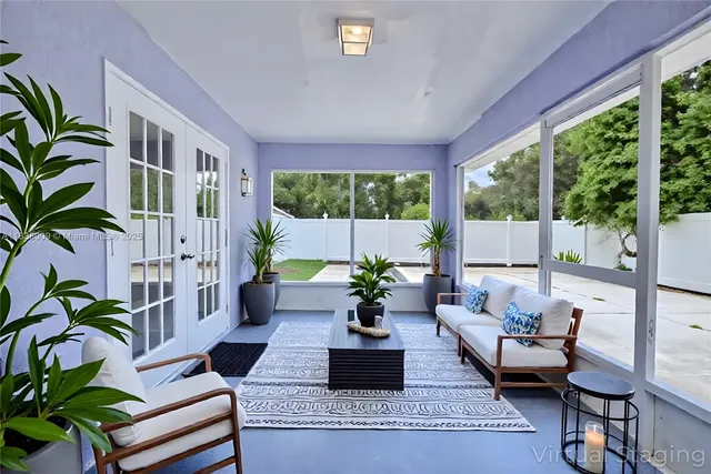 a living room with patio furniture and a potted plant