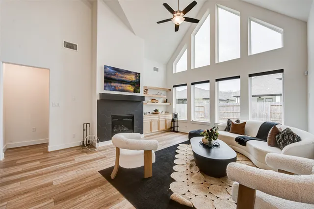a living room with furniture a fireplace and a floor to ceiling window