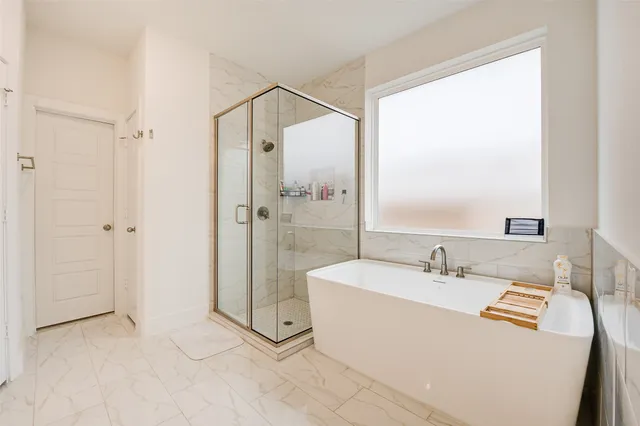 a bathroom with a tub sink shower and mirror