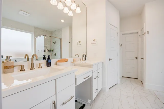 a bathroom with a sink double vanity granite and a mirror