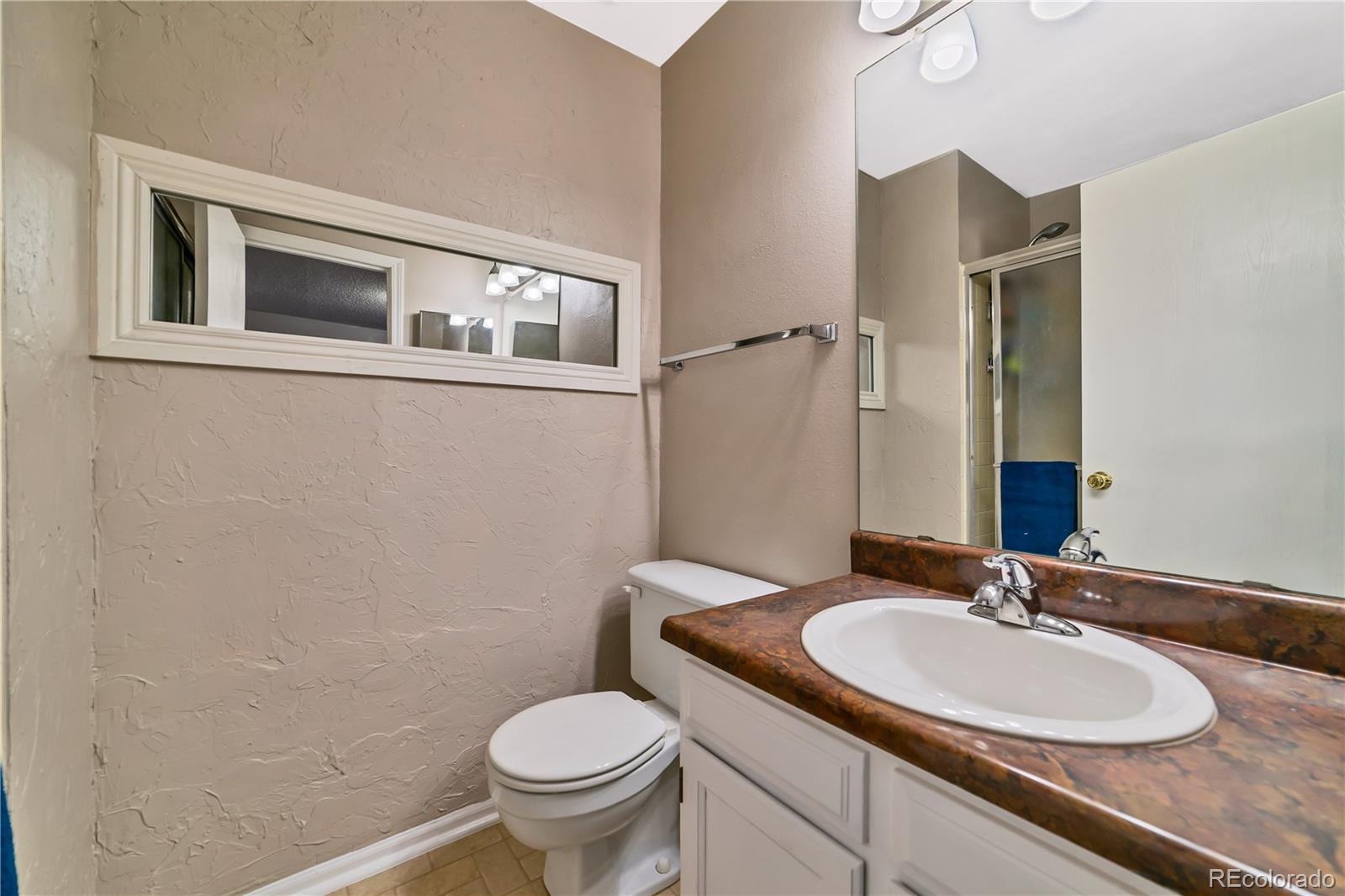 3796 South Ceylon Way Aurora, CO 80013 - Photo 12 of 16 a bathroom with a granite countertop sink toilet and mirror