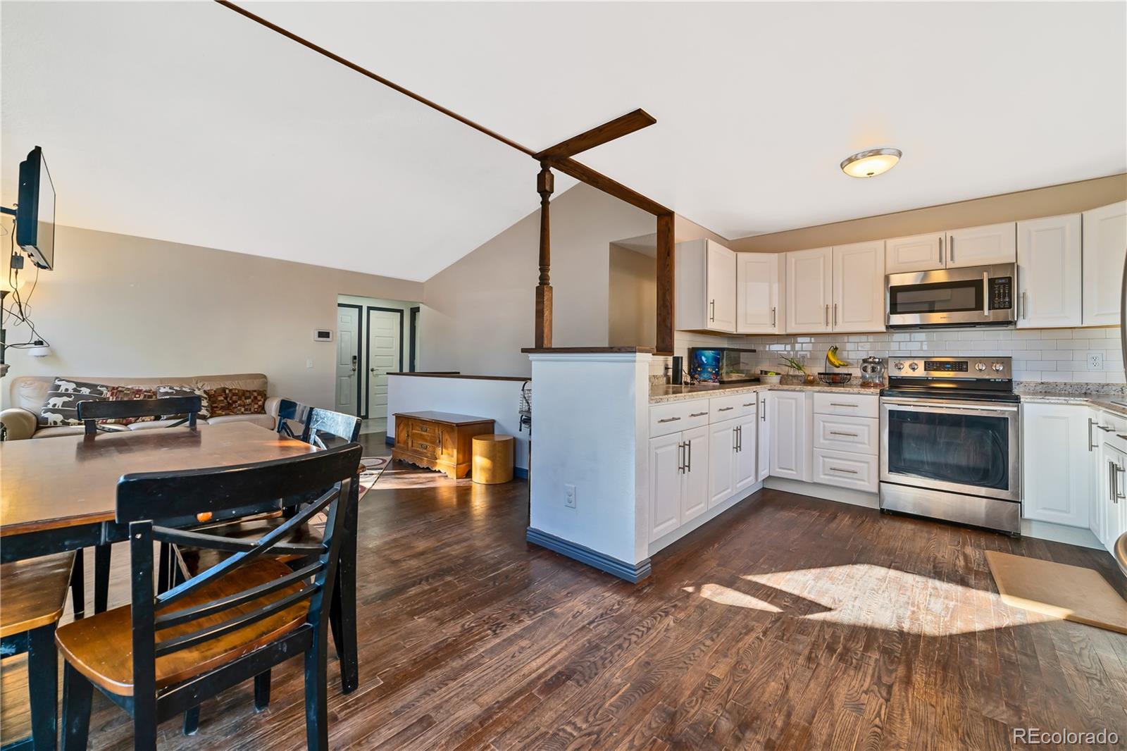 3796 South Ceylon Way Aurora, CO 80013 - Photo 3 of 16 a kitchen with kitchen island a stove a sink and a refrigerator