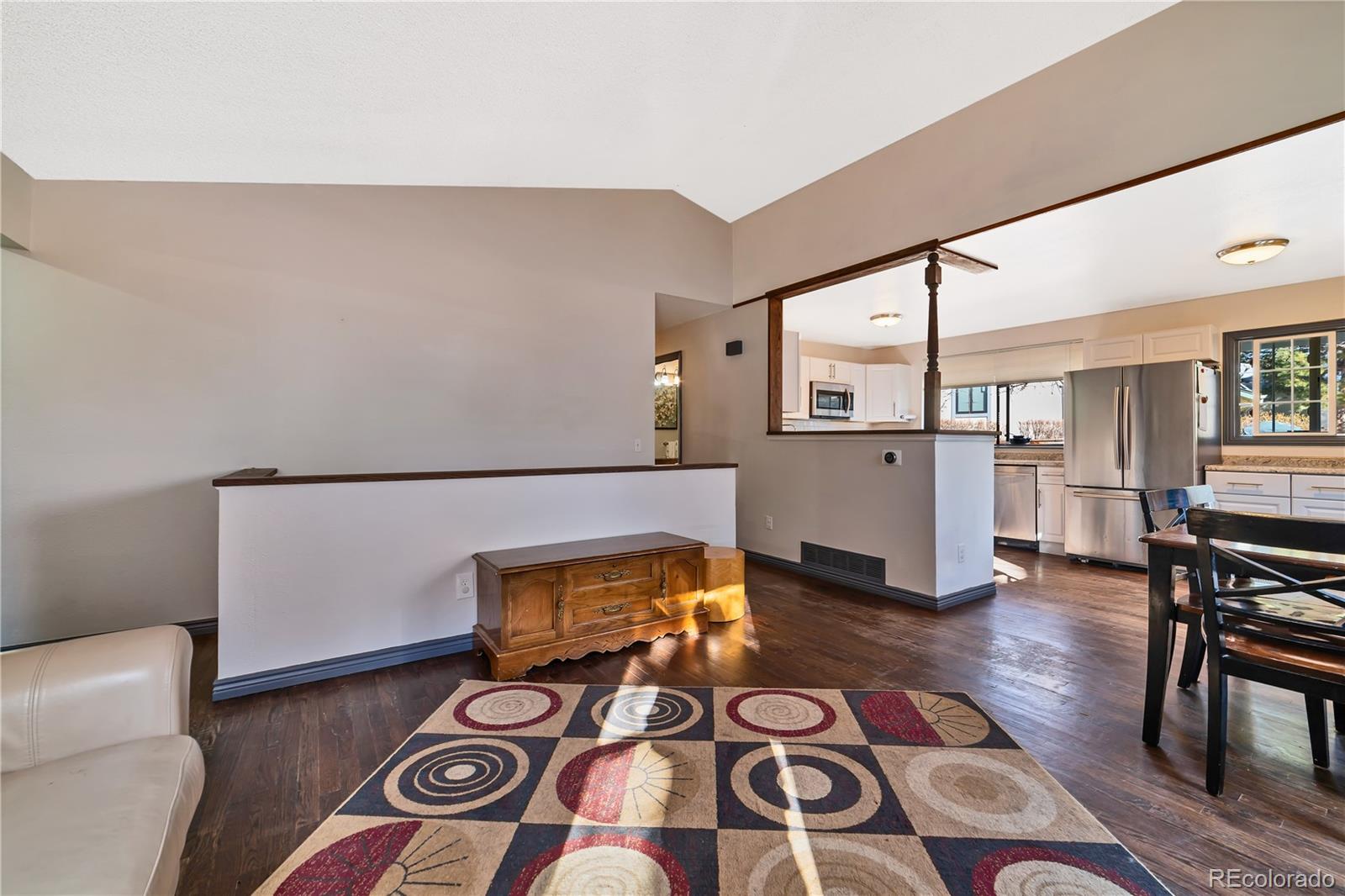 3796 South Ceylon Way Aurora, CO 80013 - Photo 5 of 16 a living room with stainless steel appliances furniture a rug and a kitchen view