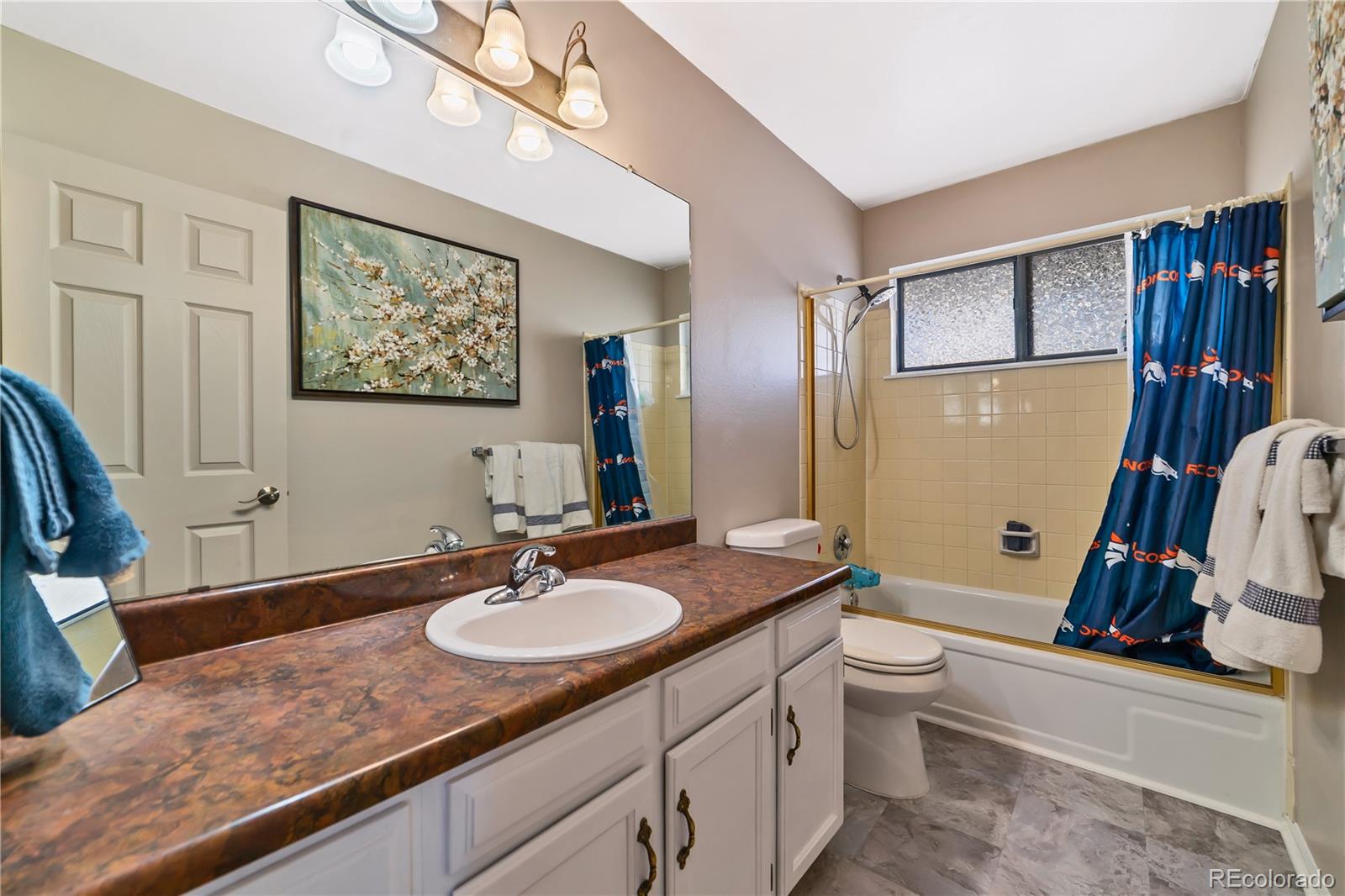 3796 South Ceylon Way Aurora, CO 80013 - Photo 9 of 16 a bathroom with a granite countertop sink a mirror a vanity and a bathtub