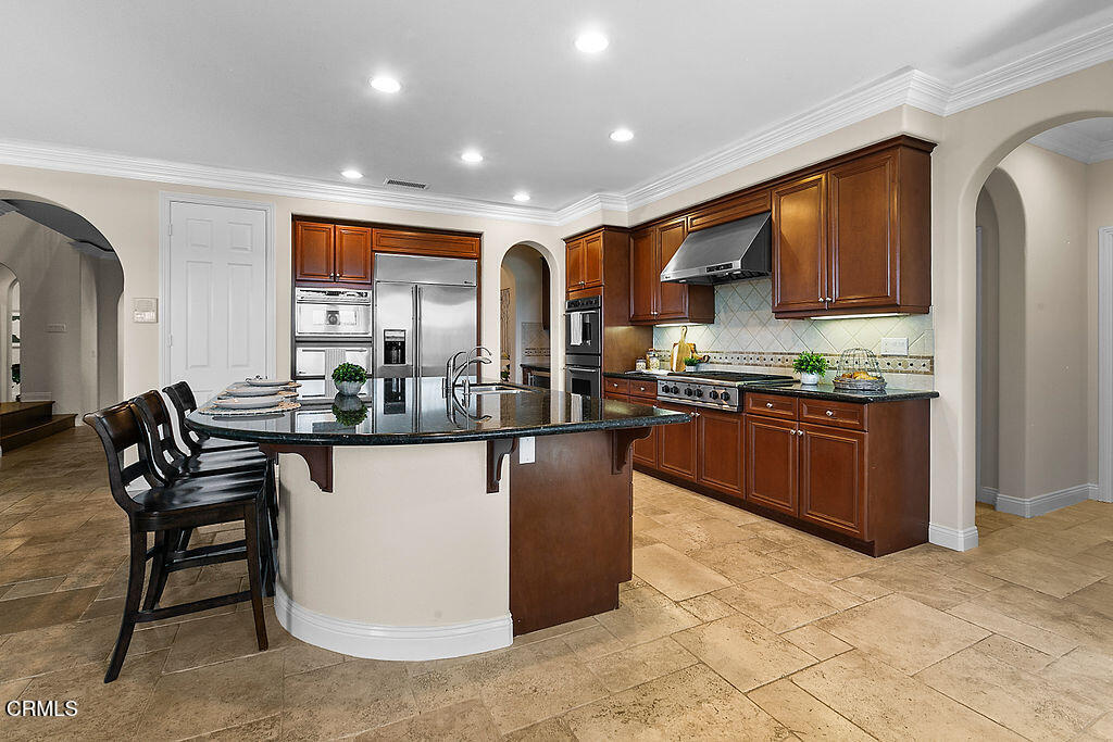 14216 Oneida Court Moorpark, CA 93021 - Photo 17 of 75 a kitchen with stainless steel appliances granite countertop a stove a sink a refrigerator and chairs