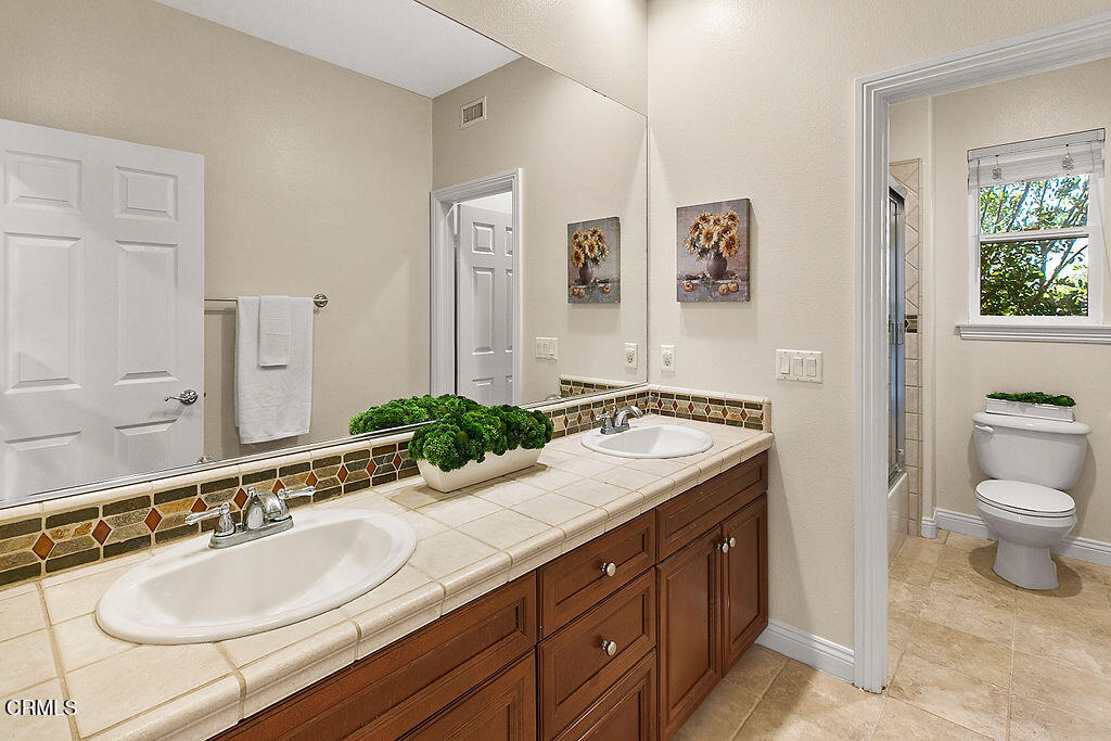 14216 Oneida Court Moorpark, CA 93021 - Photo 43 of 75 a bathroom with a granite countertop sink and a mirror