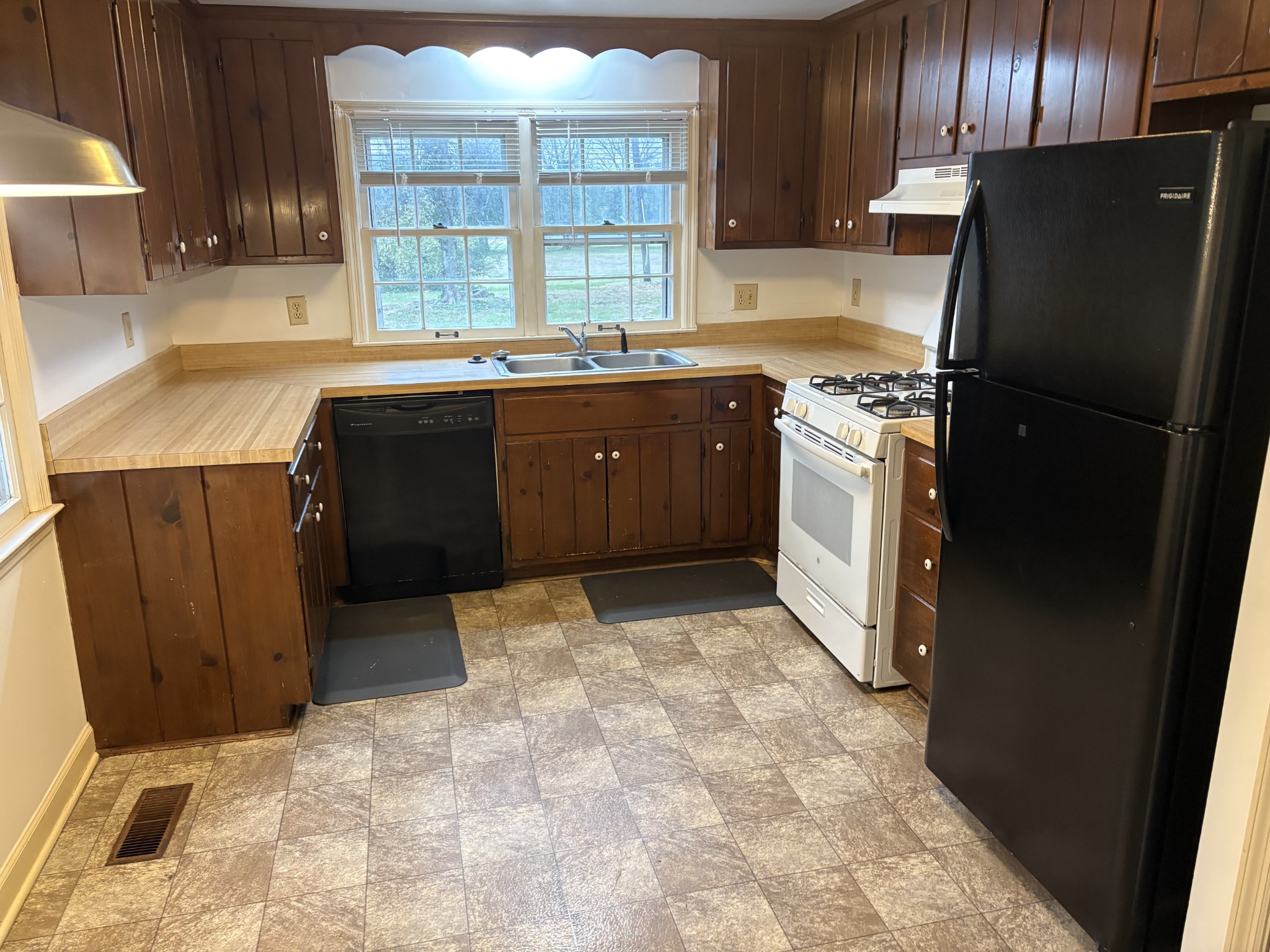 3088 Hillsboro Road Brentwood, TN 37027 - Photo 7 of 18 a kitchen with a sink a refrigerator and wooden cabinets