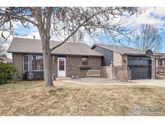 a front view of a house with yard and trees in the background