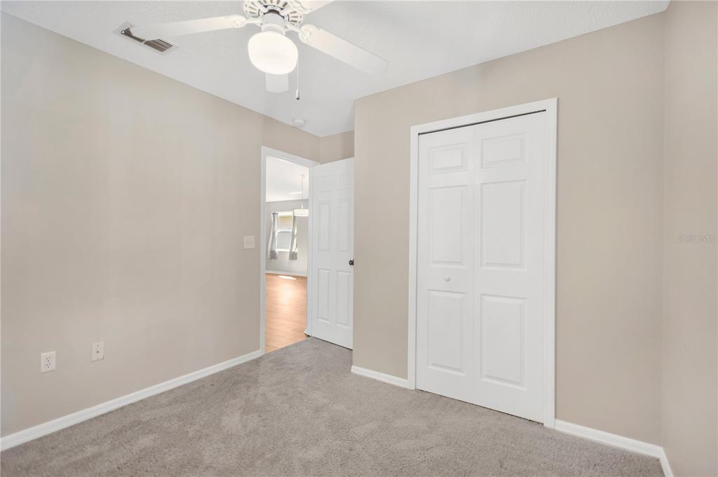 3600 Raintree Terrace Lakeland, FL 33803 - Photo 12 of 22 an empty room with a chandelier fan and closet