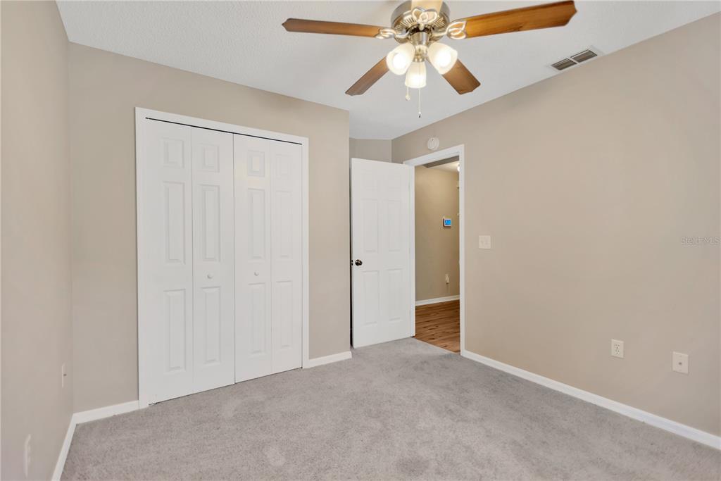 3600 Raintree Terrace Lakeland, FL 33803 - Photo 16 of 22 an empty room with a chandelier fan and closet area
