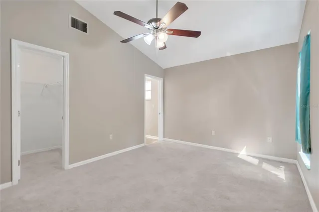 an empty room with a window and a fan