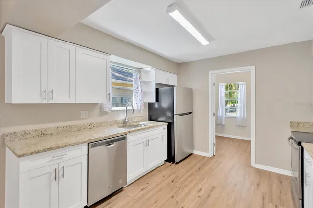 a kitchen with cabinets appliances and a wooden floor
