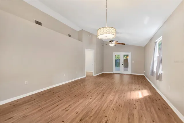 an empty room with a chandelier fan and closet