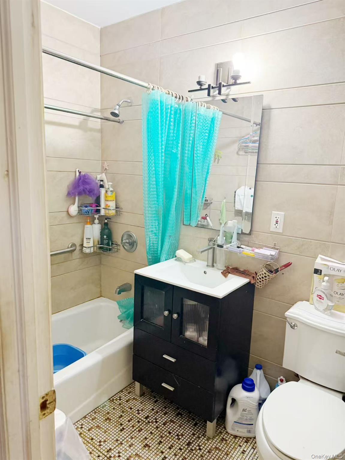 8510 Elmhurst Avenue, Unit 1C Queens, NY 11373 - Photo 6 of 9 a bathroom with a sink vanity mirror bathtub and toilet