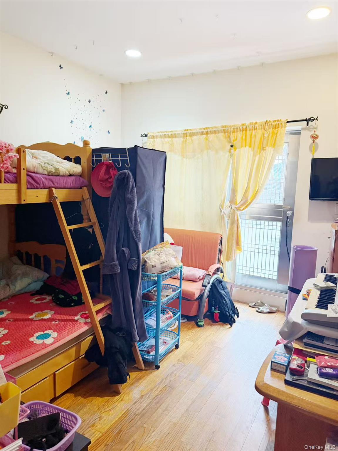 8510 Elmhurst Avenue, Unit 1C Queens, NY 11373 - Photo 7 of 9 a bedroom with furniture and a wooden floor