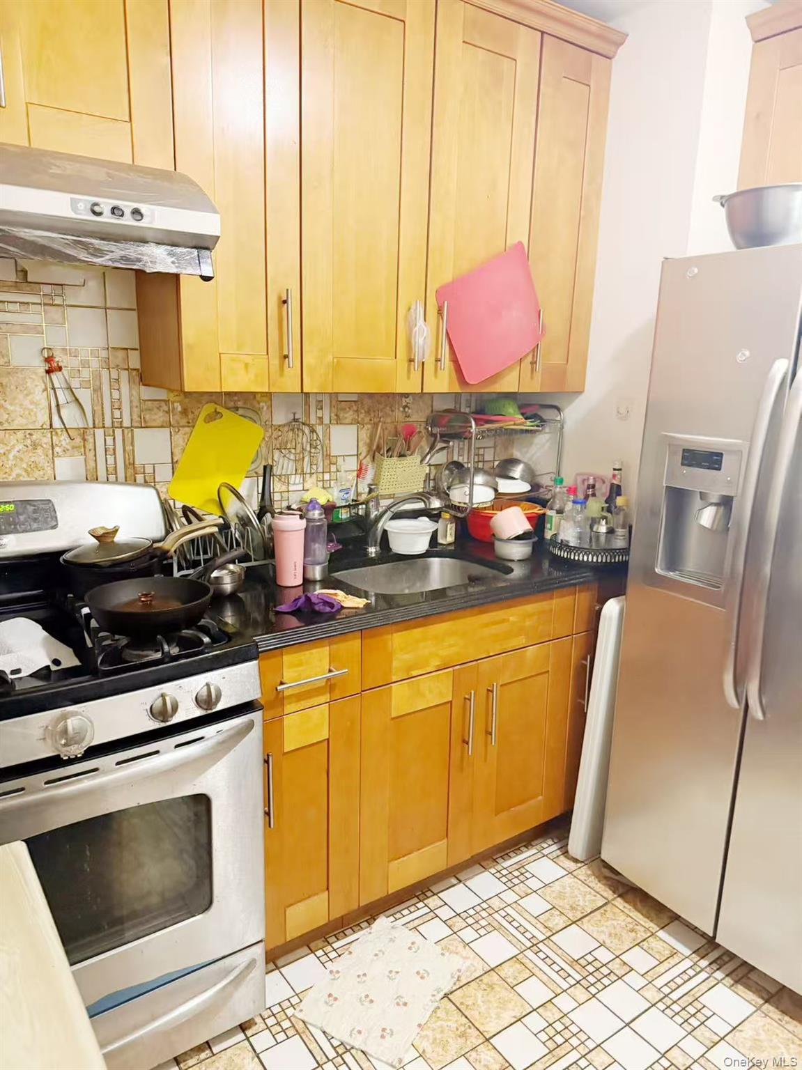 8510 Elmhurst Avenue, Unit 1C Queens, NY 11373 - Photo 8 of 9 a kitchen with stainless steel appliances granite countertop a sink dishwasher stove and white cabinets with wooden floor