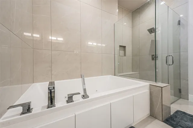 a spacious bathroom with a tub sink and mirror