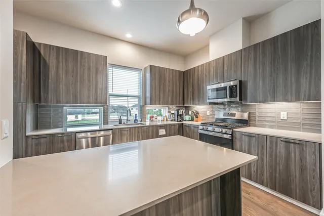 a kitchen with kitchen island microwave stove refrigerator and cabinets