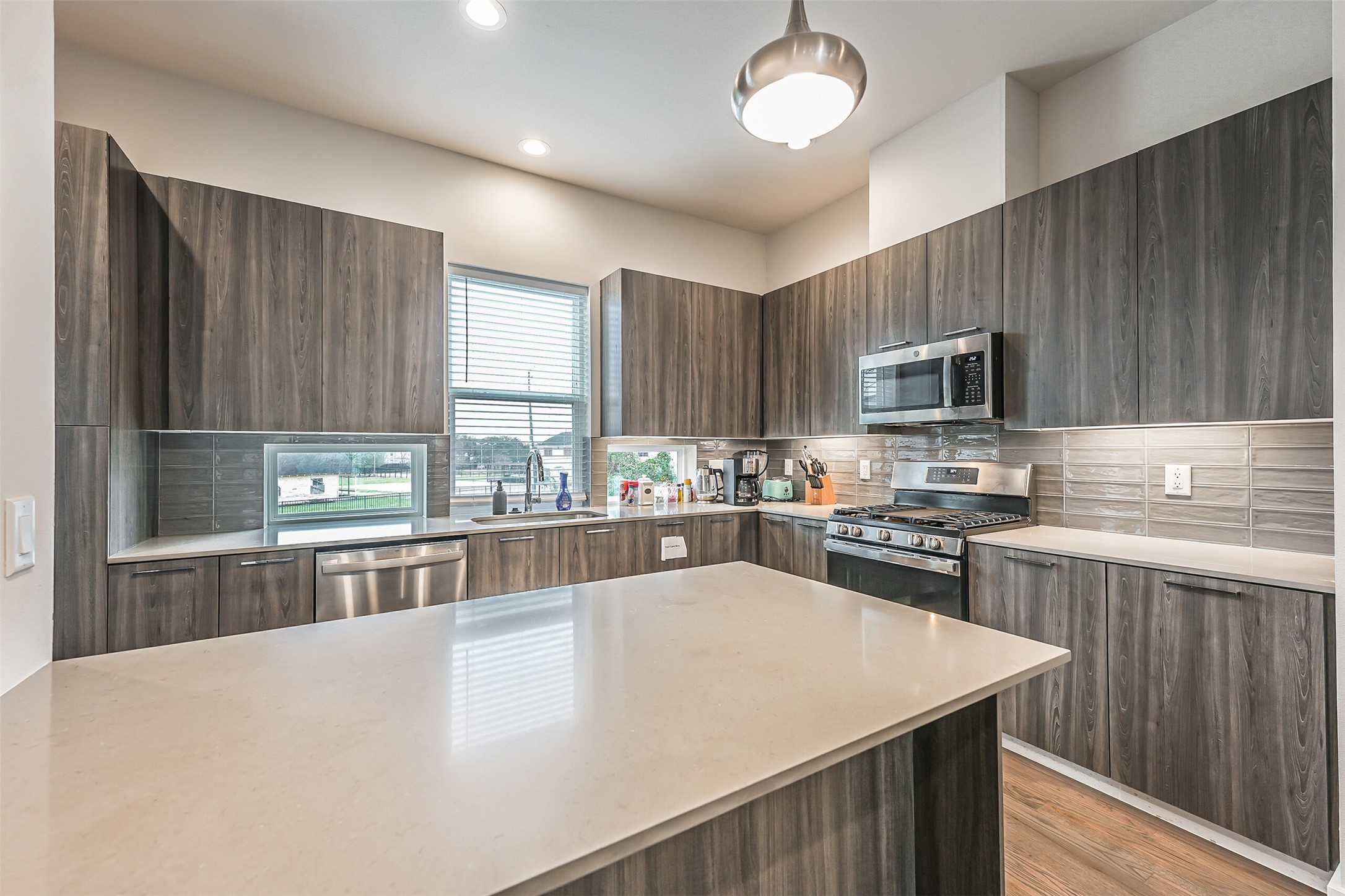 2136 Dennis Street Houston, TX 77004 - Photo 8 of 49 a large kitchen with granite countertop a stove top oven a sink dishwasher and wooden cabinets with wooden floor
