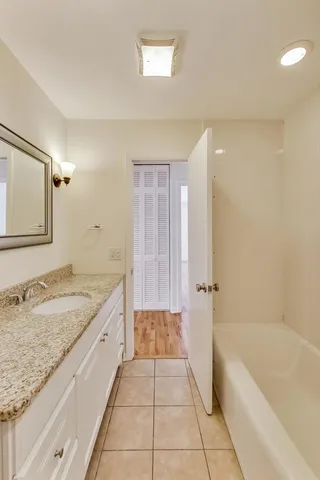 a bathroom with a granite countertop sink a toilet and bathtub