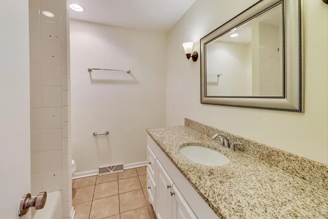 a bathroom with a granite countertop sink a mirror and a shower