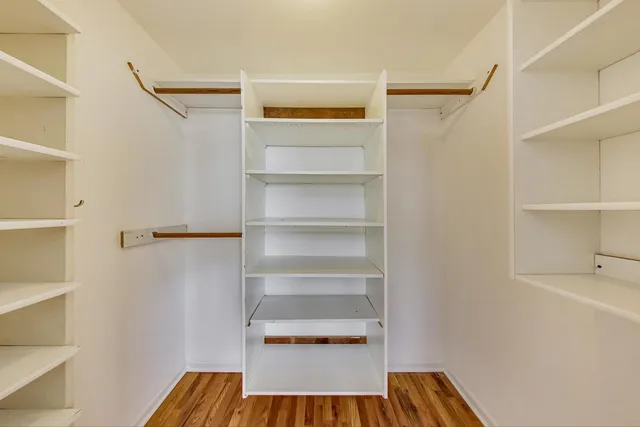 a view of walk in closet with empty racks