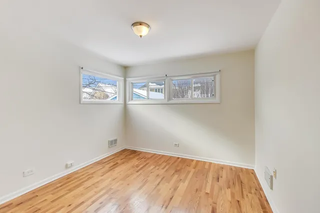an empty room with a wooden floor and a window