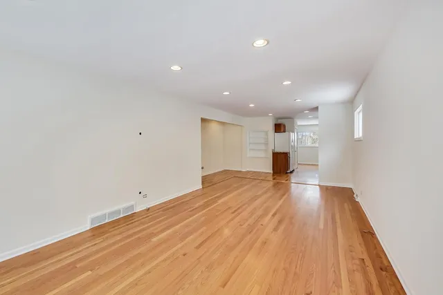a view of empty room with wooden floor