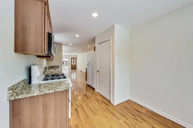 a kitchen with stainless steel appliances granite countertop a stove a sink and a refrigerator