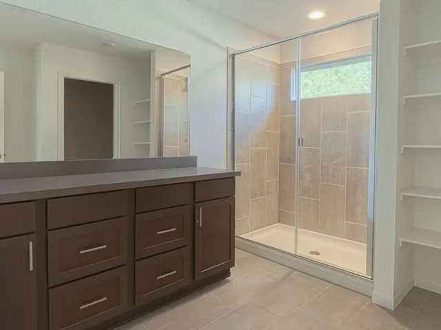a bathroom with a shower a mirror and a sink