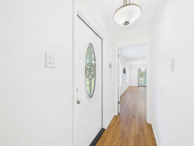 a large white kitchen with a large window a sink and cabinets
