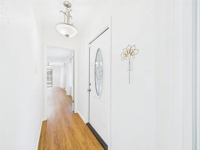 a view of a room with wooden floors and ceiling fan