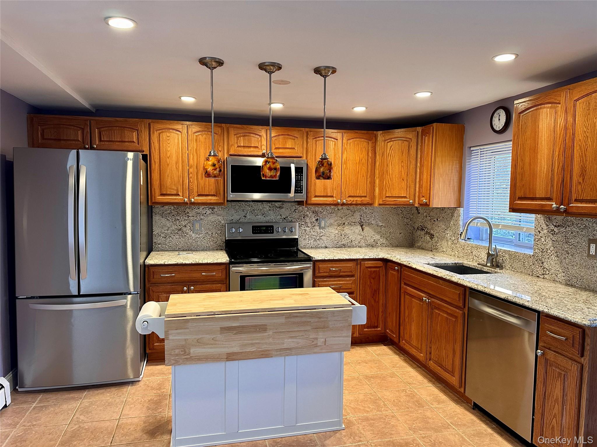 5 Forge Gate Drive, Unit C3 Cold Spring, NY 10516 - Photo 7 of 10 a kitchen with kitchen island stainless steel appliances a sink a stove a refrigerator cabinets and a kitchen island